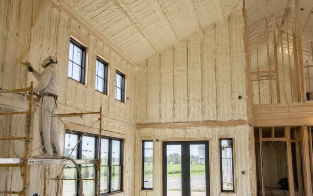 Open stud bays of a new great room filled with spray foam insulation before the drywall